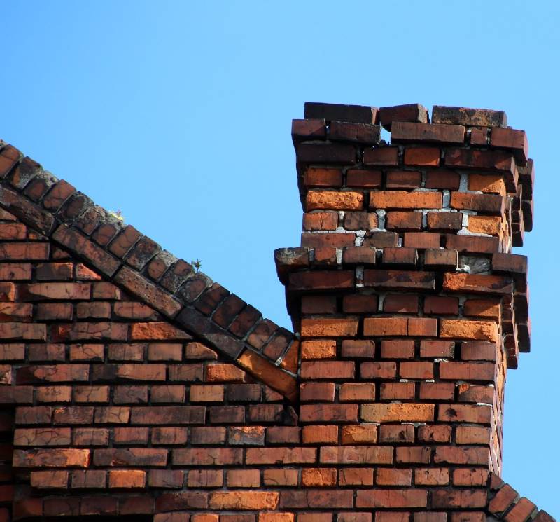 Damaged chimney on an Groton home showing cracks and missing mortar